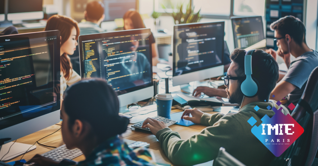 alt="Open space informatique avec plusieurs personnes travaillant sur des ordinateurs affichant du code source, illustrant la programmation, le développement logiciel, le travail collaboratif et la formation au numérique, avec le logo IMIE Paris. étudiants en cours après admission"